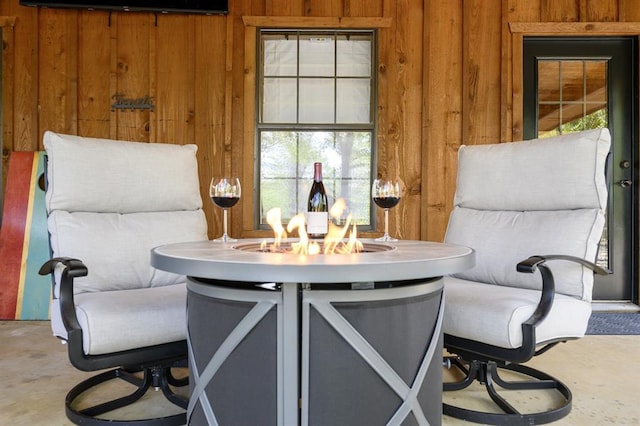 99 Sawtooth Pine Rd, Broken Bow, OK 74728 - dining space featuring wooden walls and concrete flooring