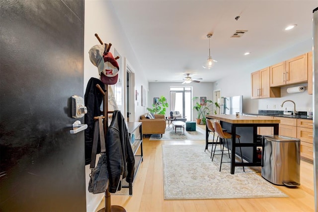 444 N Central Ave Unit 106, Oklahoma City, OK 73104 - kitchen with light brown cabinets, freestanding refrigerator, light wood finished floors, open floor plan, and ceiling fan