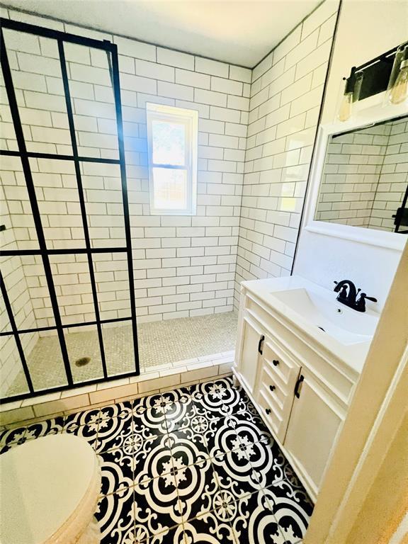 209 SW 6th St, Blanchard, OK 73010 - full bath with tiled shower, vanity, and tile patterned flooring