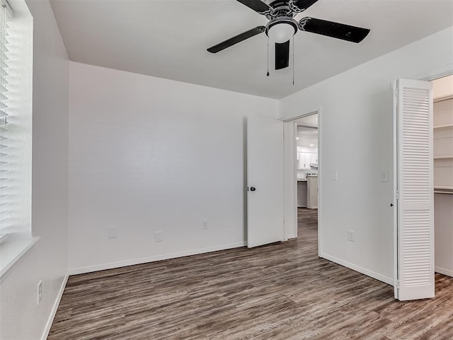 209 SW 6th St, Blanchard, OK 73010 - unfurnished bedroom featuring wood finished floors, a walk in closet, a closet, and a ceiling fan