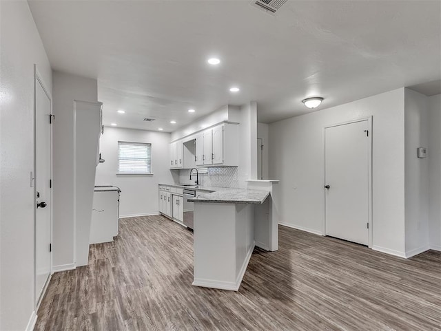 209 SW 6th St, Blanchard, OK 73010 - kitchen with wood finished floors, a peninsula, white cabinets, and recessed lighting