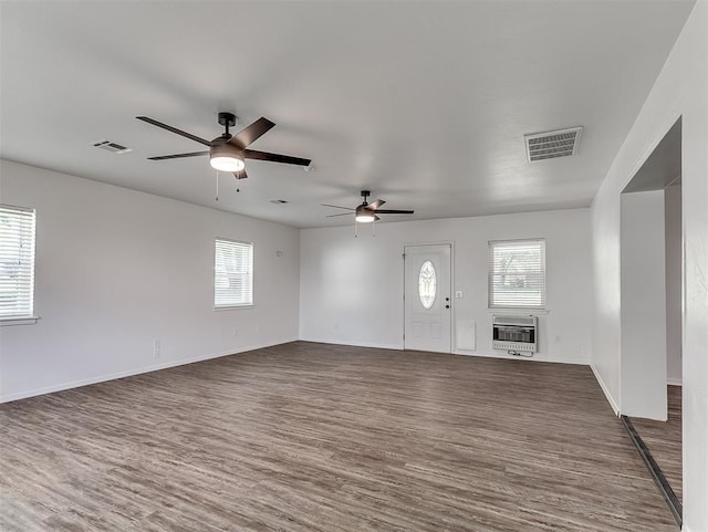 209 SW 6th St, Blanchard, OK 73010 - unfurnished living room with heating unit, a ceiling fan, dark wood-type flooring, and plenty of natural light