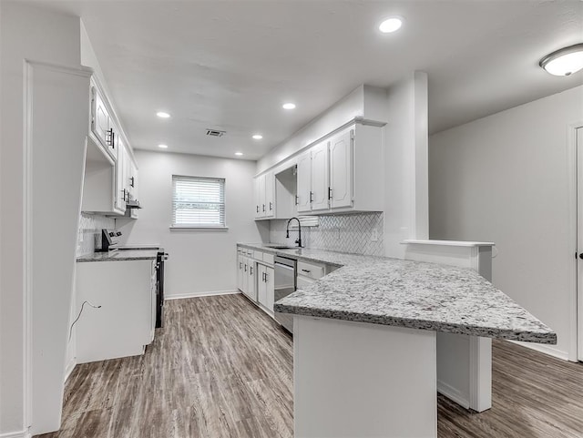 209 SW 6th St, Blanchard, OK 73010 - kitchen featuring a peninsula, electric range, dishwasher, backsplash, and wood finished floors