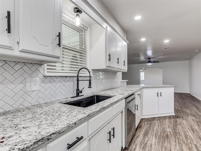 209 SW 6th St, Blanchard, OK 73010 - kitchen featuring stainless steel dishwasher, a peninsula, light wood-type flooring, a ceiling fan, and decorative backsplash