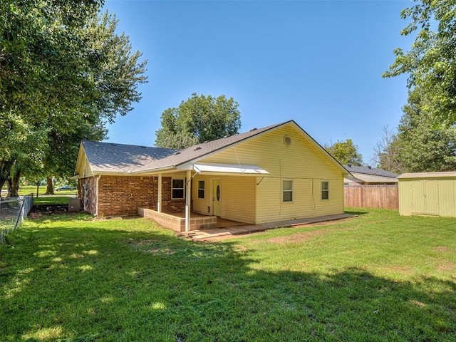 209 SW 6th St, Blanchard, OK 73010 - back of house featuring a shed, brick siding, a patio, and roof with shingles