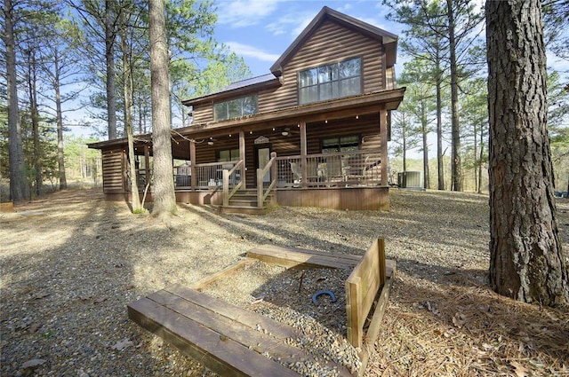 318 Camp Ranch Rd, Broken Bow, OK 74728 - view of front of home featuring log veneer siding and covered porch