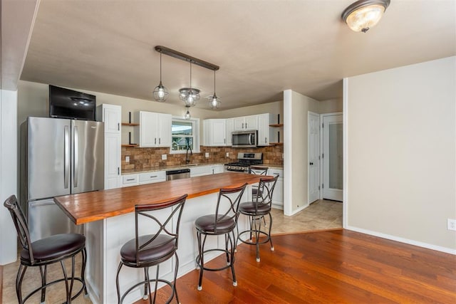 822 W Broadway St, Okemah, OK 74859 - kitchen with butcher block countertops, stainless steel appliances, open shelves, and light wood-type flooring