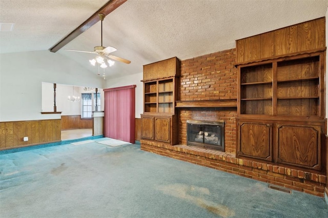 929 NE 5th St, Moore, OK 73160 - unfurnished living room featuring a ceiling fan, a textured ceiling, carpet, wainscoting, and a fireplace