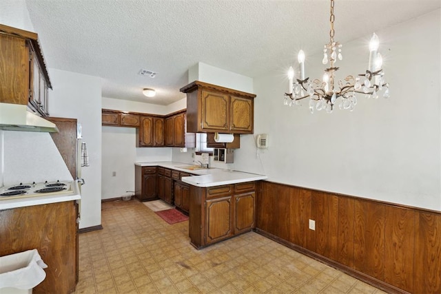 929 NE 5th St, Moore, OK 73160 - kitchen featuring under cabinet range hood, white electric stovetop, light flooring, light countertops, and a wainscoted wall
