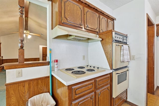 929 NE 5th St, Moore, OK 73160 - kitchen with white appliances, under cabinet range hood, brown cabinetry, a ceiling fan, and light countertops