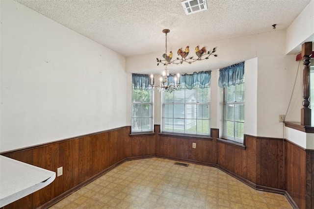 929 NE 5th St, Moore, OK 73160 - unfurnished dining area with a wainscoted wall, wooden walls, plenty of natural light, a chandelier, and light flooring