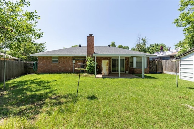 929 NE 5th St, Moore, OK 73160 - back of house with a fenced backyard, a patio, a chimney, and brick siding