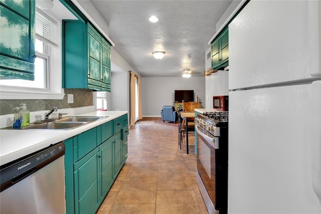 1001 NW 2nd St, Moore, OK 73160 - kitchen featuring appliances with stainless steel finishes, green cabinets, light countertops, and backsplash