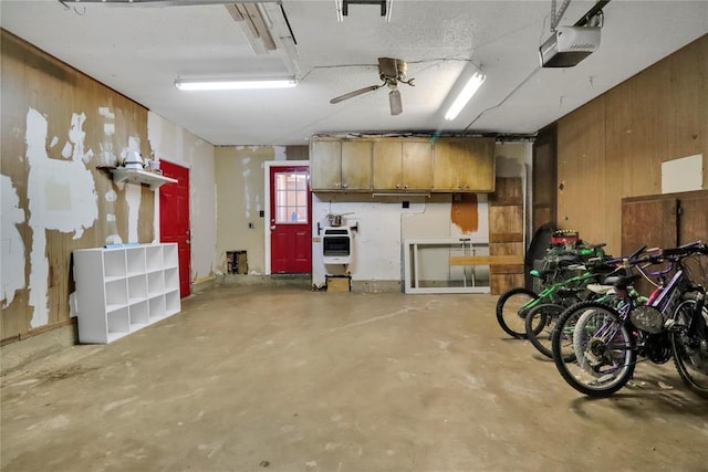 1001 NW 2nd St, Moore, OK 73160 - garage with a garage door opener, wood walls, and a ceiling fan
