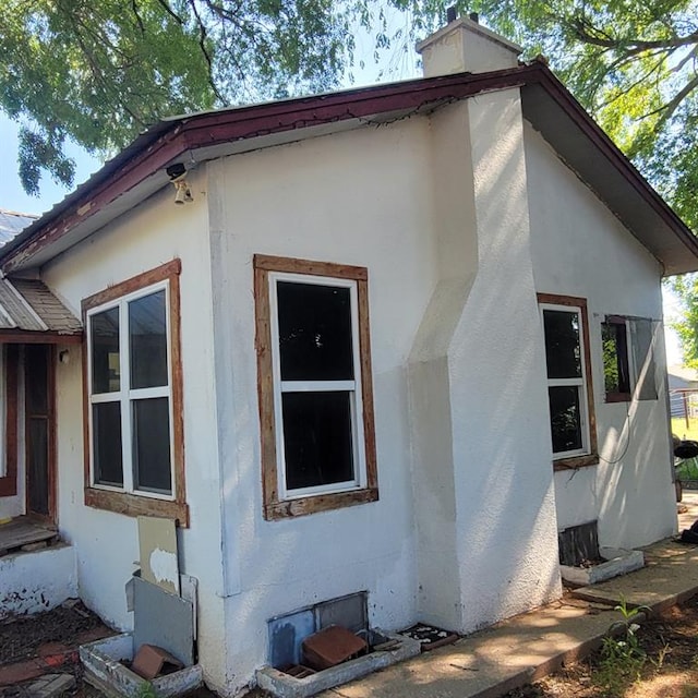 608 7th St, Woodward, OK 73801 - view of side of home with stucco siding and a chimney
