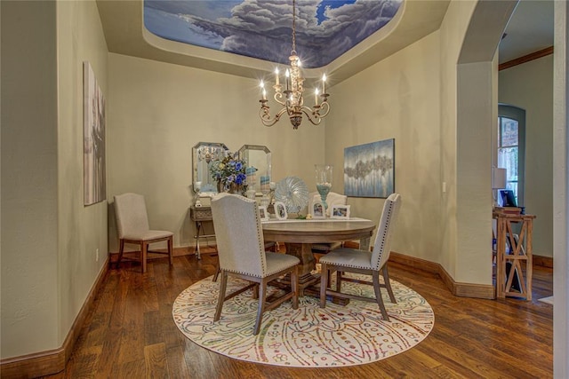 dining space with a chandelier, wood finished floors, and arched walkways
