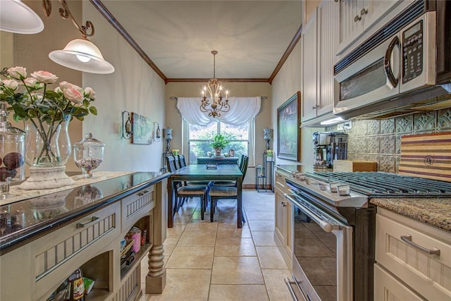 kitchen featuring stainless steel appliances, a chandelier, tasteful backsplash, crown molding, and hanging light fixtures