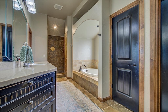 full bathroom featuring tile patterned floors, vanity, and a bath