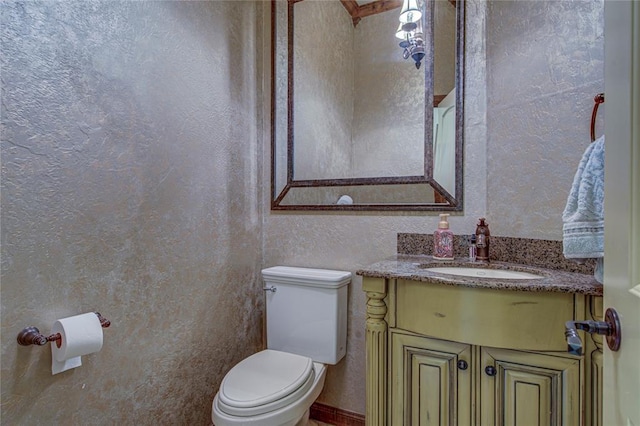 half bath featuring vanity and a textured wall