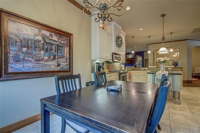 dining space with a chandelier, light tile patterned floors, crown molding, arched walkways, and recessed lighting