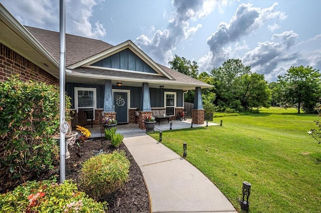 4450 Buffalo Hl, Guthrie, OK 73044 - view of front of property featuring board and batten siding, brick siding, roof with shingles, covered porch, and a front lawn
