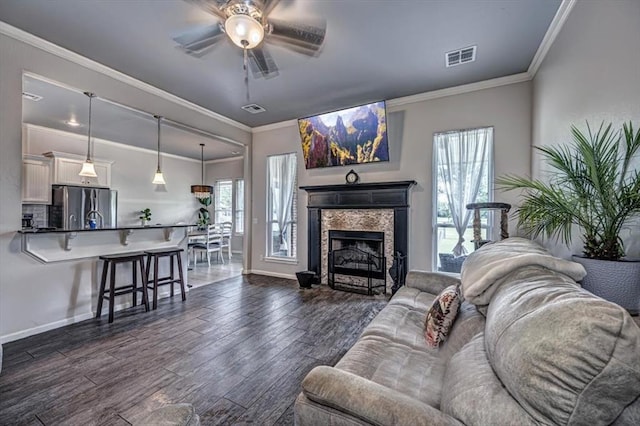 4450 Buffalo Hl, Guthrie, OK 73044 - living room with ceiling fan, dark wood-type flooring, crown molding, and a fireplace