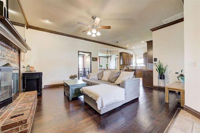 1106 Polk St, Piedmont, OK 73078 - living area featuring crown molding, ceiling fan, a fireplace, and dark wood-style floors