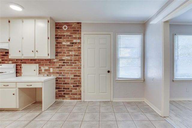 1417 Downing St, The Village, OK 73120 - kitchen with plenty of natural light, white cabinets, light countertops, light tile patterned floors, and ornamental molding