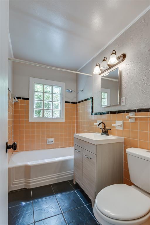 1417 Downing St, The Village, OK 73120 - full bath with shower / washtub combination, vanity, tile walls, tile patterned floors, and wainscoting