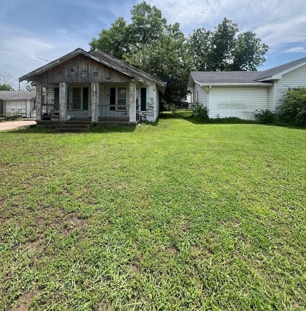 1139 E 2nd St, Cushing, OK 74023 - view of green lawn featuring covered porch