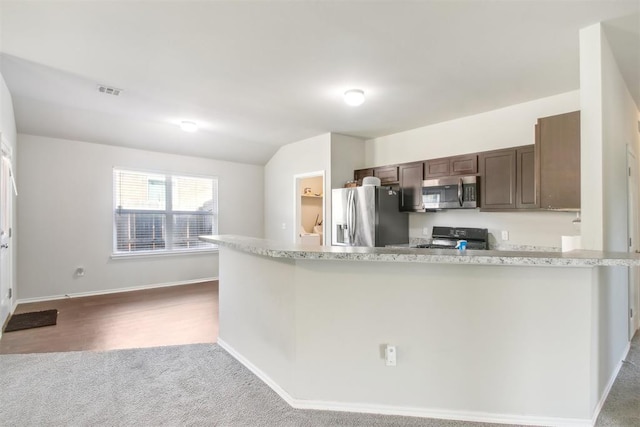 11712 NW 130th St, Piedmont, OK 73078 - kitchen featuring stainless steel appliances, dark brown cabinetry, vaulted ceiling, carpet flooring, and a peninsula