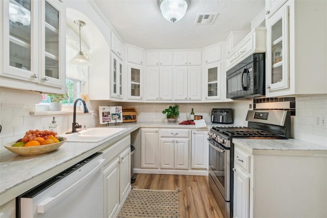 1726 Caddell Ln, Norman, OK 73069 - kitchen featuring stainless steel gas range, black microwave, dishwasher, and white cabinets