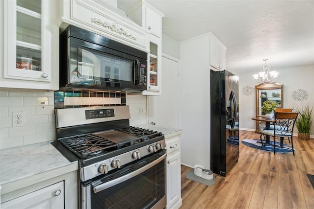 1726 Caddell Ln, Norman, OK 73069 - kitchen featuring black appliances, white cabinets, a chandelier, and light wood finished floors