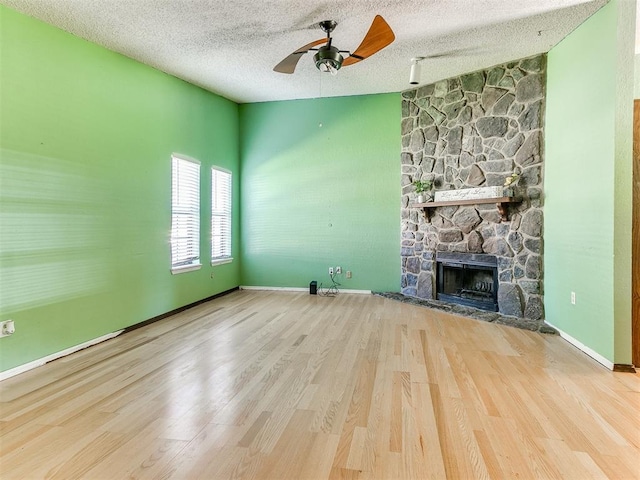 1916 Twin Tree Dr, Norman, OK 73071 - unfurnished living room featuring a ceiling fan, wood finished floors, a fireplace, and a textured ceiling