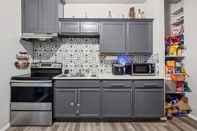 334 SE 24th St, Oklahoma City, OK 73129 - kitchen featuring stainless steel appliances, under cabinet range hood, gray cabinets, and light wood-style floors