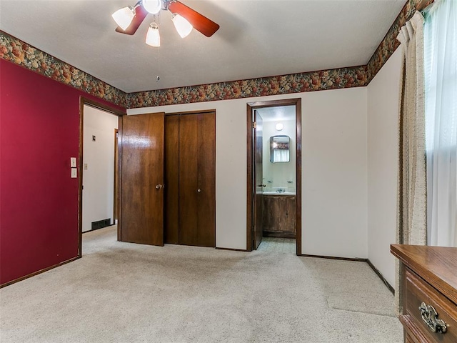 2120 N Divis Ave, Bethany, OK 73008 - unfurnished bedroom featuring light carpet, a closet, connected bathroom, and a ceiling fan