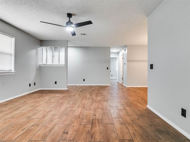 1810 Spring Ave, Stroud, OK 74079 - empty room with wood finished floors, a ceiling fan, and a textured ceiling