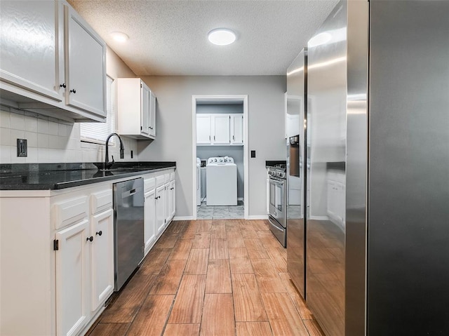 1810 Spring Ave, Stroud, OK 74079 - kitchen with stainless steel appliances, white cabinets, backsplash, a textured ceiling, and light wood-type flooring