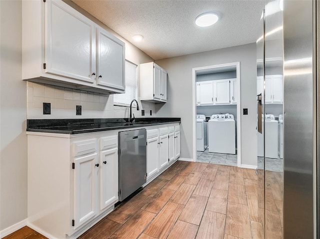 1810 Spring Ave, Stroud, OK 74079 - kitchen featuring stainless steel dishwasher, washing machine and dryer, white cabinetry, light wood-type flooring, and a textured ceiling