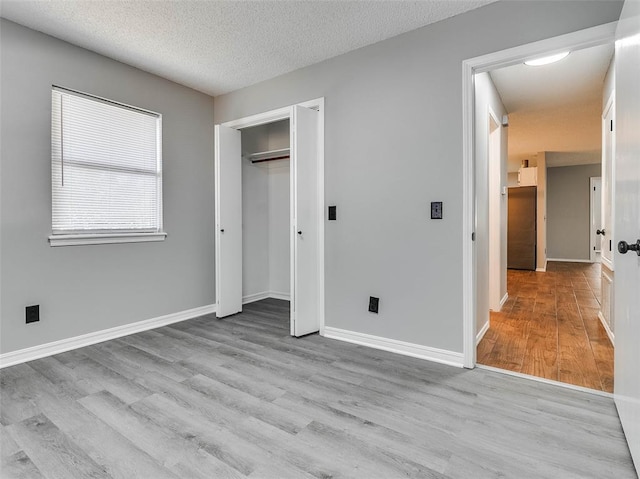 1810 Spring Ave, Stroud, OK 74079 - unfurnished bedroom featuring wood finished floors, a textured ceiling, and a closet