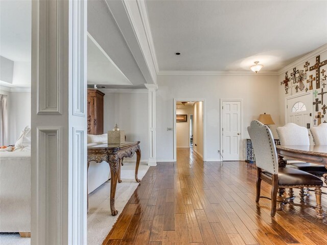2404 Pawnee Xing, Edmond, OK 73034 - dining space featuring ornamental molding, wood-type flooring, and decorative columns