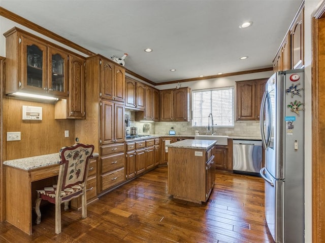 2404 Pawnee Xing, Edmond, OK 73034 - kitchen with appliances with stainless steel finishes, ornamental molding, dark wood-type flooring, backsplash, and brown cabinets