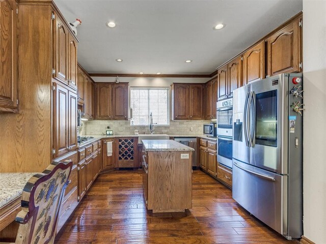 2404 Pawnee Xing, Edmond, OK 73034 - kitchen featuring appliances with stainless steel finishes, a center island, dark wood finished floors, tasteful backsplash, and recessed lighting
