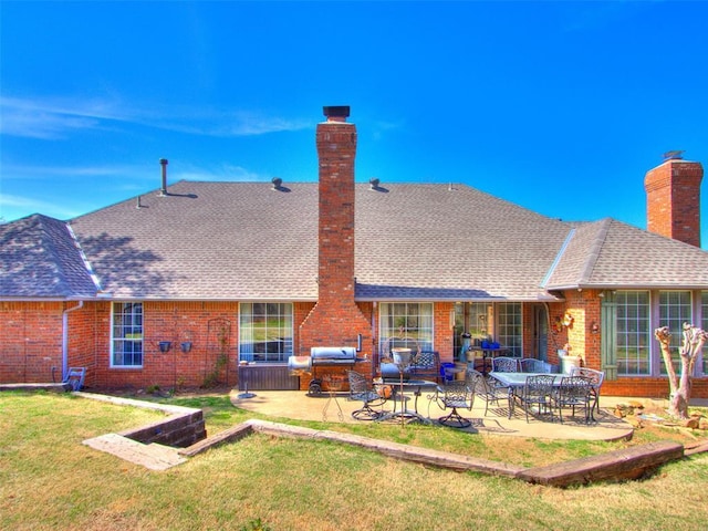 2404 Pawnee Xing, Edmond, OK 73034 - rear view of house featuring a chimney, brick siding, a patio area, a lawn, and roof with shingles