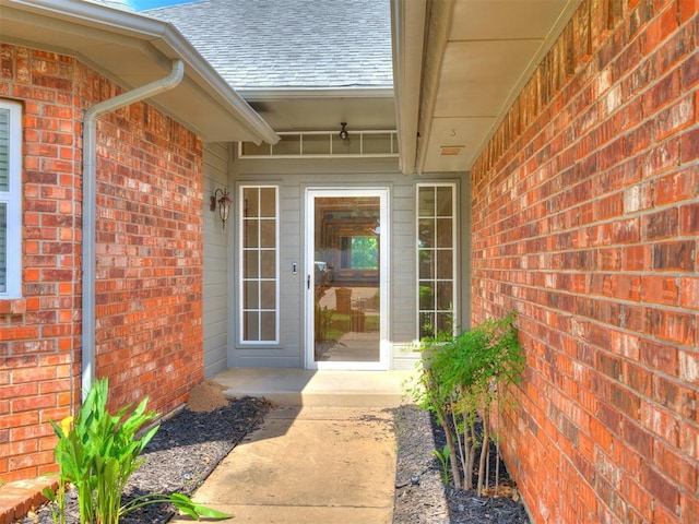 1917 Goldenrod Ln, Midwest City, OK 73130 - doorway to property with roof with shingles and brick siding