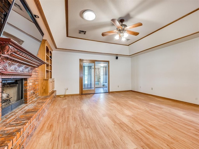 1917 Goldenrod Ln, Midwest City, OK 73130 - unfurnished living room with a fireplace, a raised ceiling, wood finished floors, ceiling fan, and built in features
