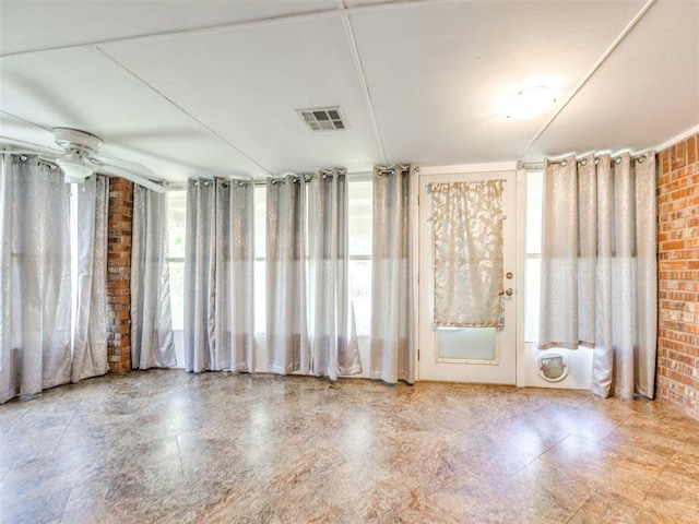 1917 Goldenrod Ln, Midwest City, OK 73130 - empty room with brick wall and a ceiling fan