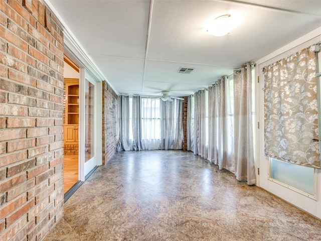 1917 Goldenrod Ln, Midwest City, OK 73130 - empty room featuring ceiling fan and brick wall