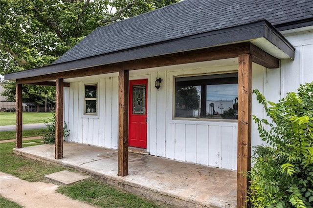103 E Ash St, Carnegie, OK 73015 - doorway to property featuring roof with shingles and a porch