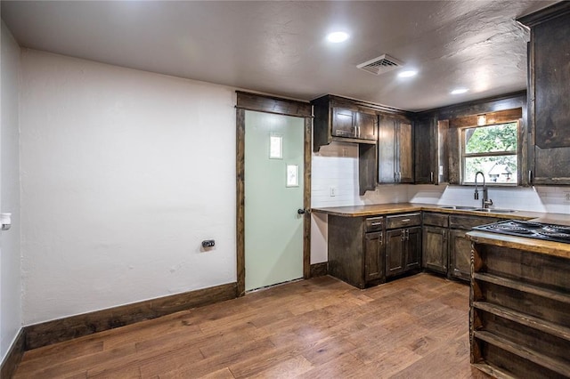 103 E Ash St, Carnegie, OK 73015 - kitchen with dark brown cabinets, wood finished floors, and recessed lighting
